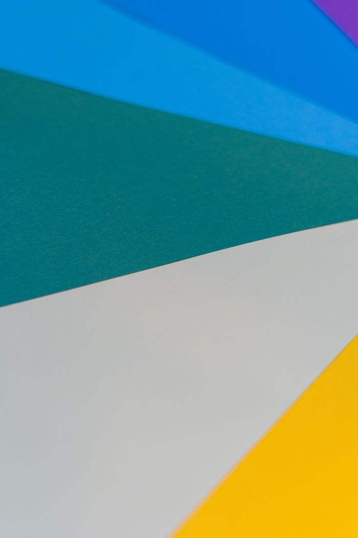 From above of bright multicolored paper with triangle shaped figures as abstract background