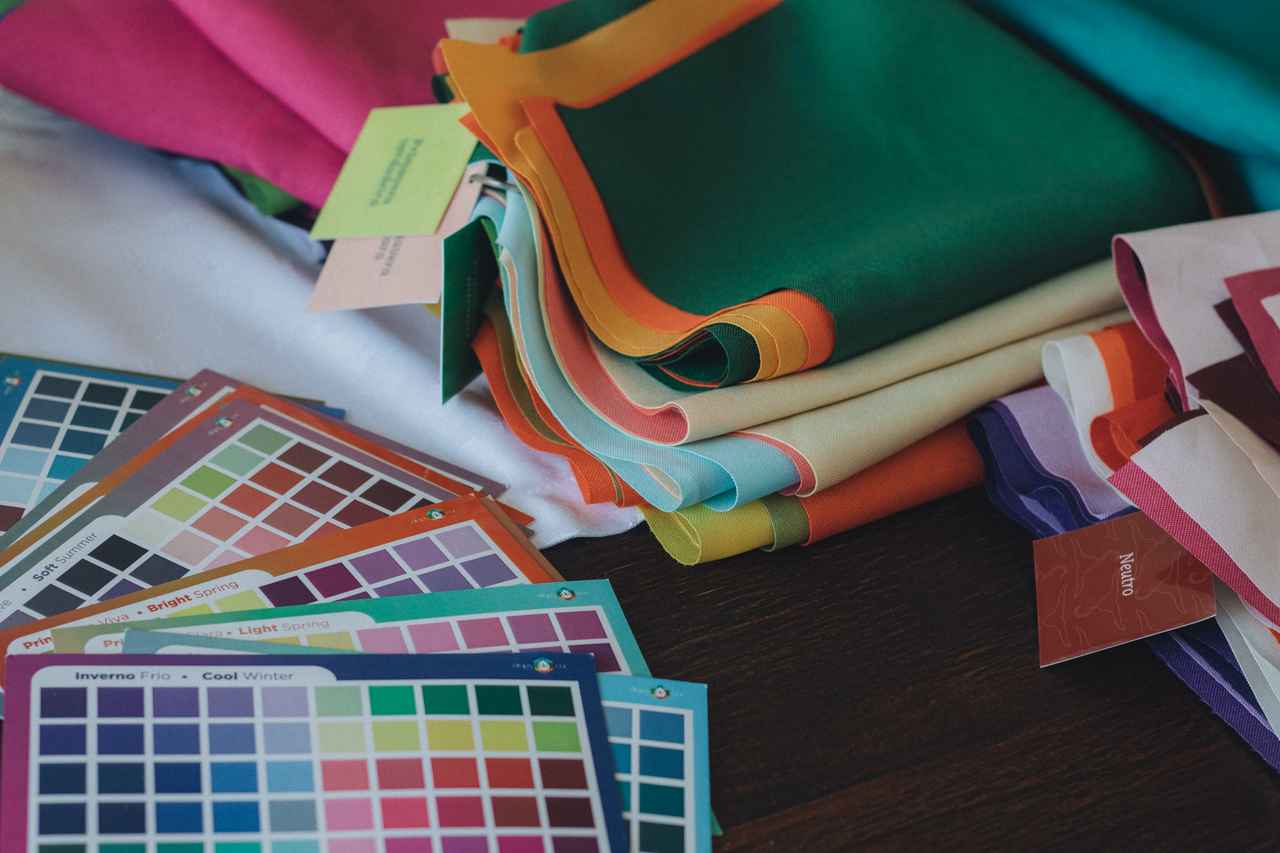 Pile of vibrant fabric swatches and color palettes for design and fashion projects.